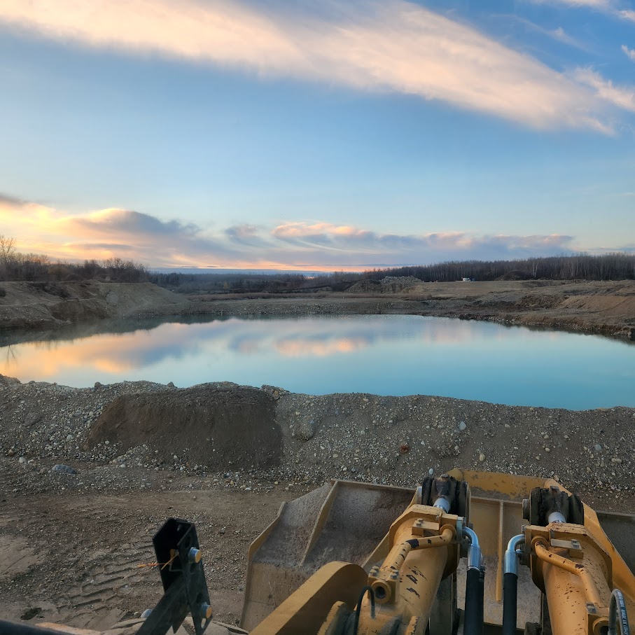 Grader on a prairie highway at golden sunset